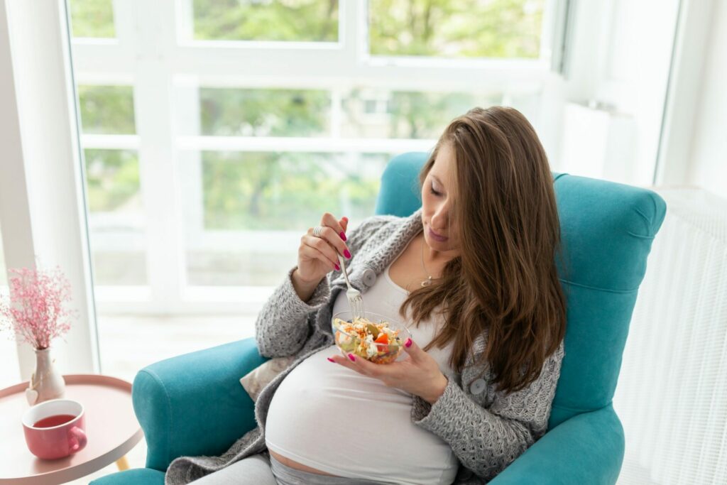 Pregnant woman eating salad